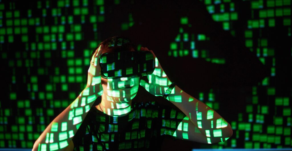 A man looking through binoculars can be seen through a screen of a green tech pattern