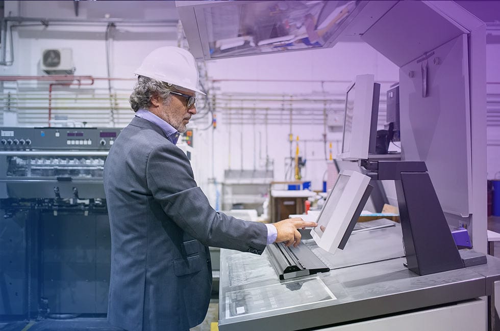 focused male plant manager operating industrial machine pushing buttons control panel