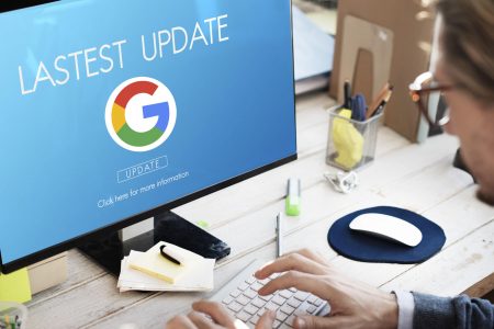 A user sits at an open laptop with the Google logo displyad onscreen along with text that reads "latest update"
